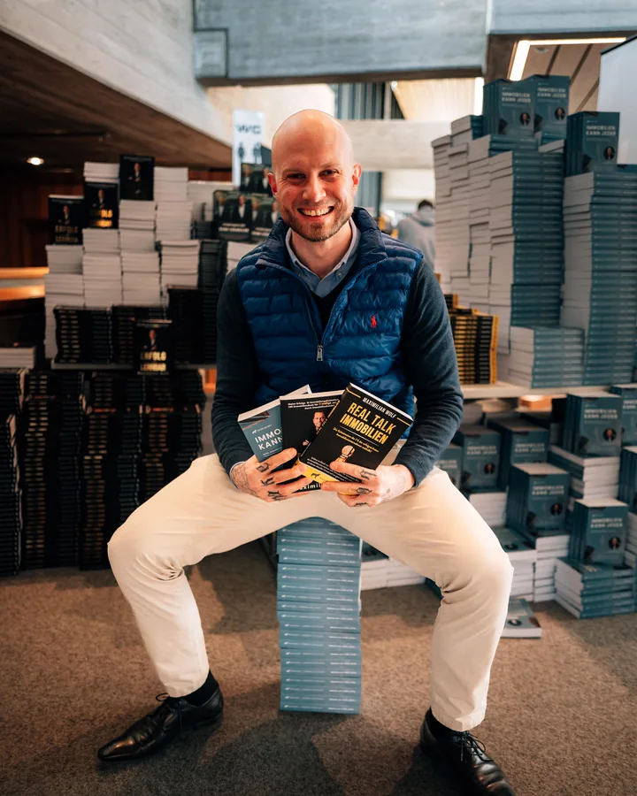 Florian Höper bei der Buchpremiere mit Bücherstapeln
